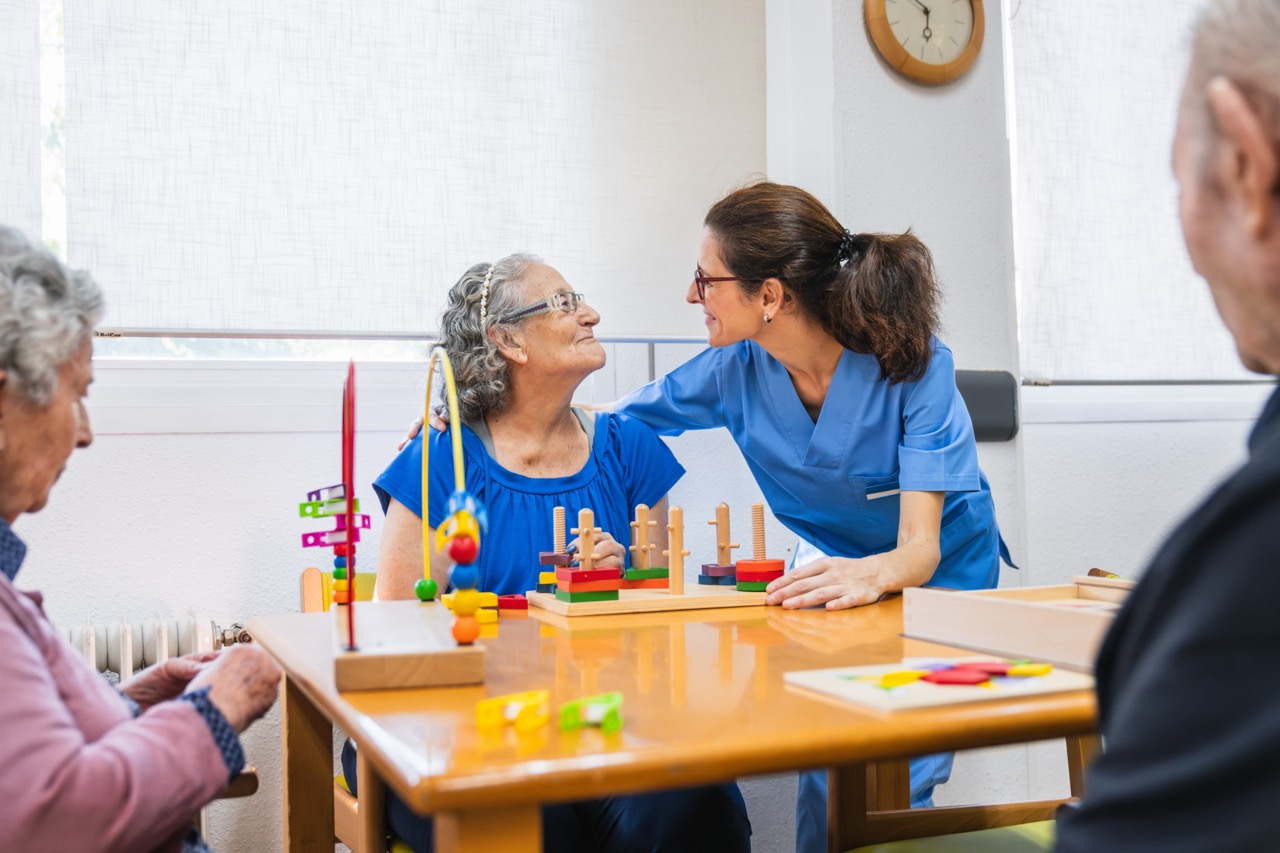 Nurse interacts warmly with elderly residents in a nursing home