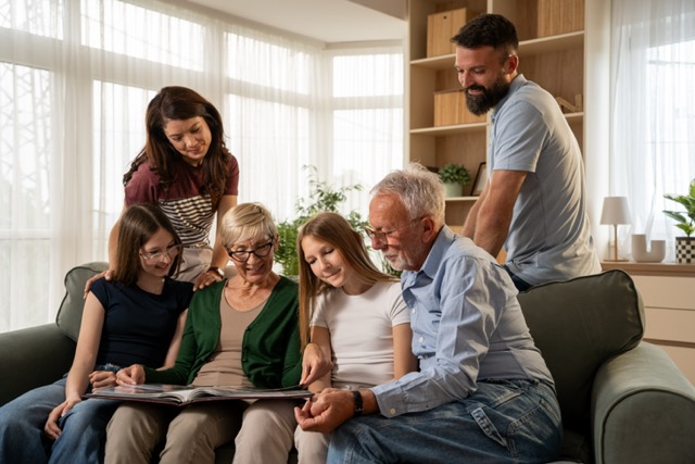 Grandmother sharing old family memories with granddaughters during multigenerational gathering