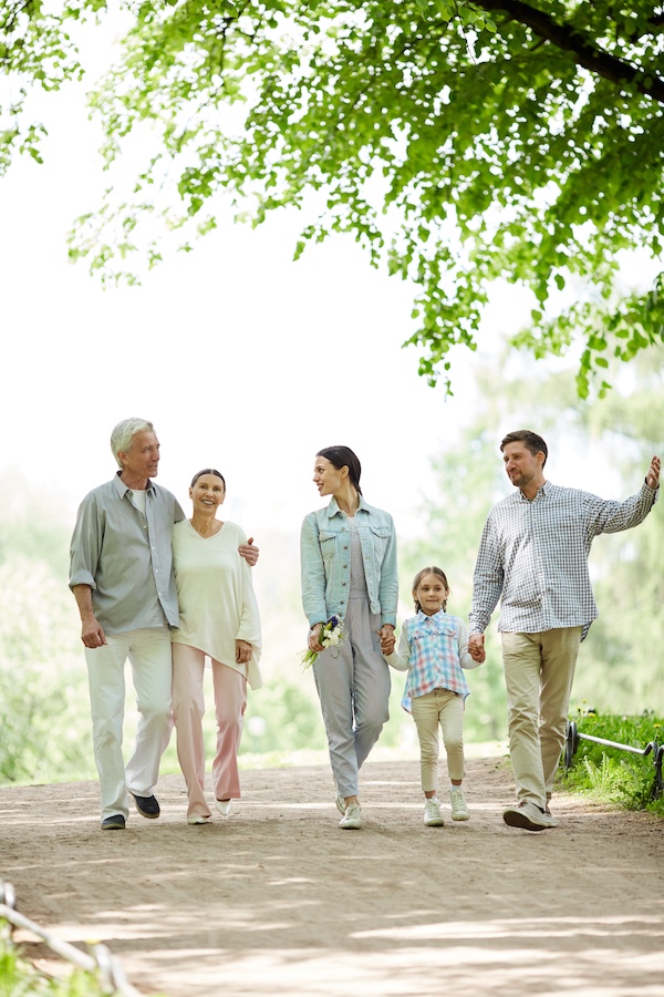 Happy family of five enjoying sunny day in park while taking walk and talking Happy family of five enjoying sunny day in park while taking walk and talking