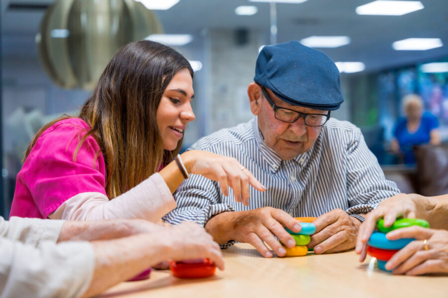 Nurse advising a elder man playing skill games